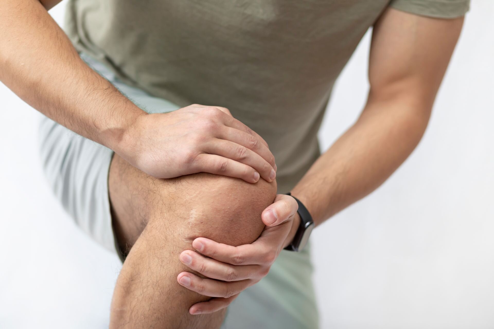 Mann hält sich schmerzendes Knie