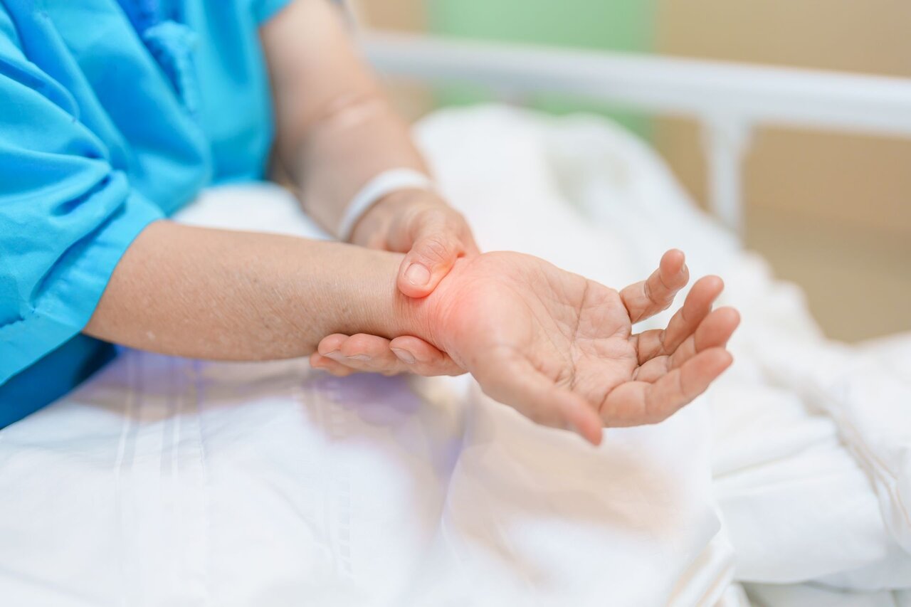 Ältere Frau hält sich schmerzhaft das entzündete Handgelenk – akute Beschwerden durch Sehnenscheidenentzündung.